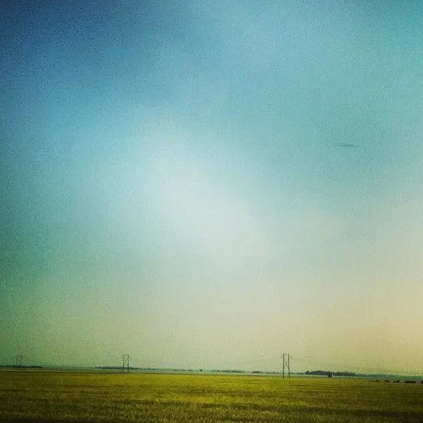 Prairie fields and power lines under a wide sky